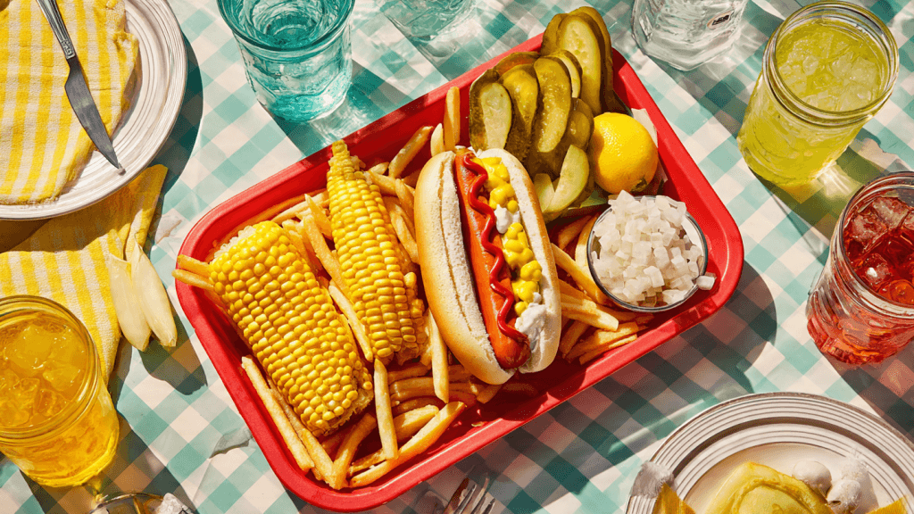 Overhead shot of a Cookout vegan tray with fries, corn, lemonade, and a bun at a fast food table in the USA.