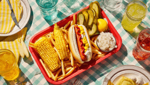 Overhead shot of a Cookout vegan tray with fries, corn, lemonade, and a bun at a fast food table in the USA.